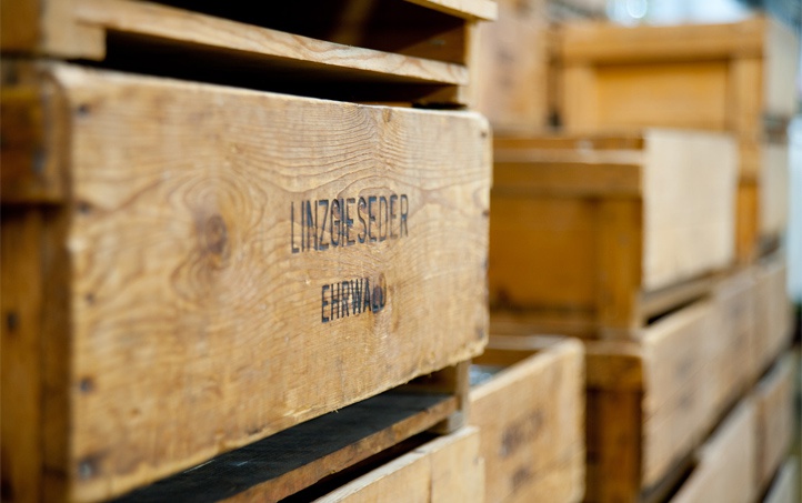 Nahaufnahme einer Holzkiste, auf der der Linzgieseder Brandstempel deutlich sichtbar ist.