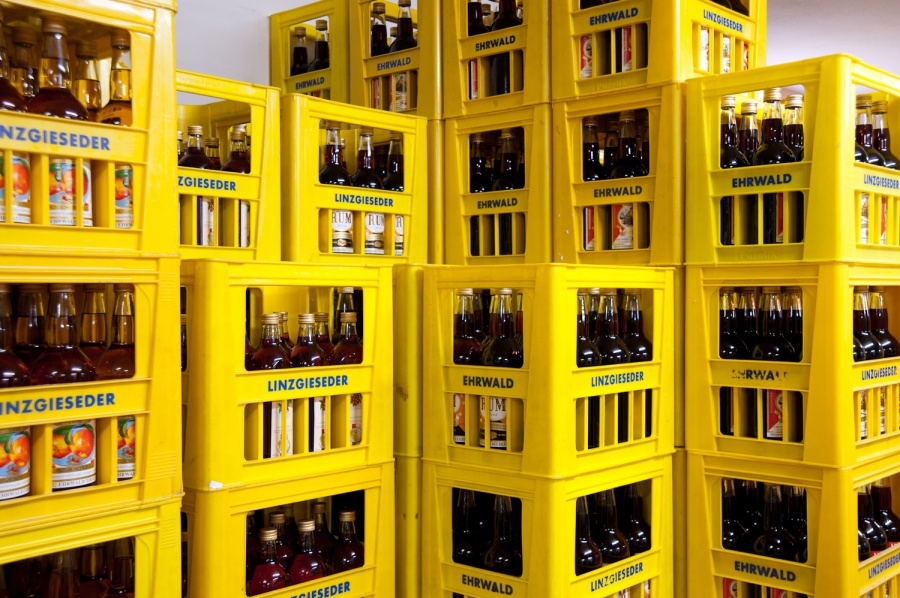 Ein Farbfoto, auf dem helle, gelbe Plastikkisten mit der Linzgieseder-Aufschrift zu sehen sind. Die Kisten sind mit vollen Getränkeflaschen gefüllt, die Eigenprodukte der Firma Linzgieseder. Der Inhalt der Flaschen ist jedoch nur zu erahnen.